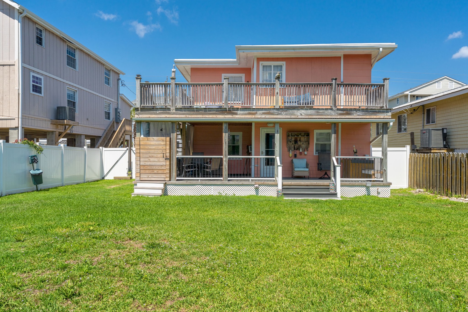 A charming coastal property with a spacious fenced backyard, dual-level decks for entertaining, and an inviting ground-floor patio—your perfect beach retreat.