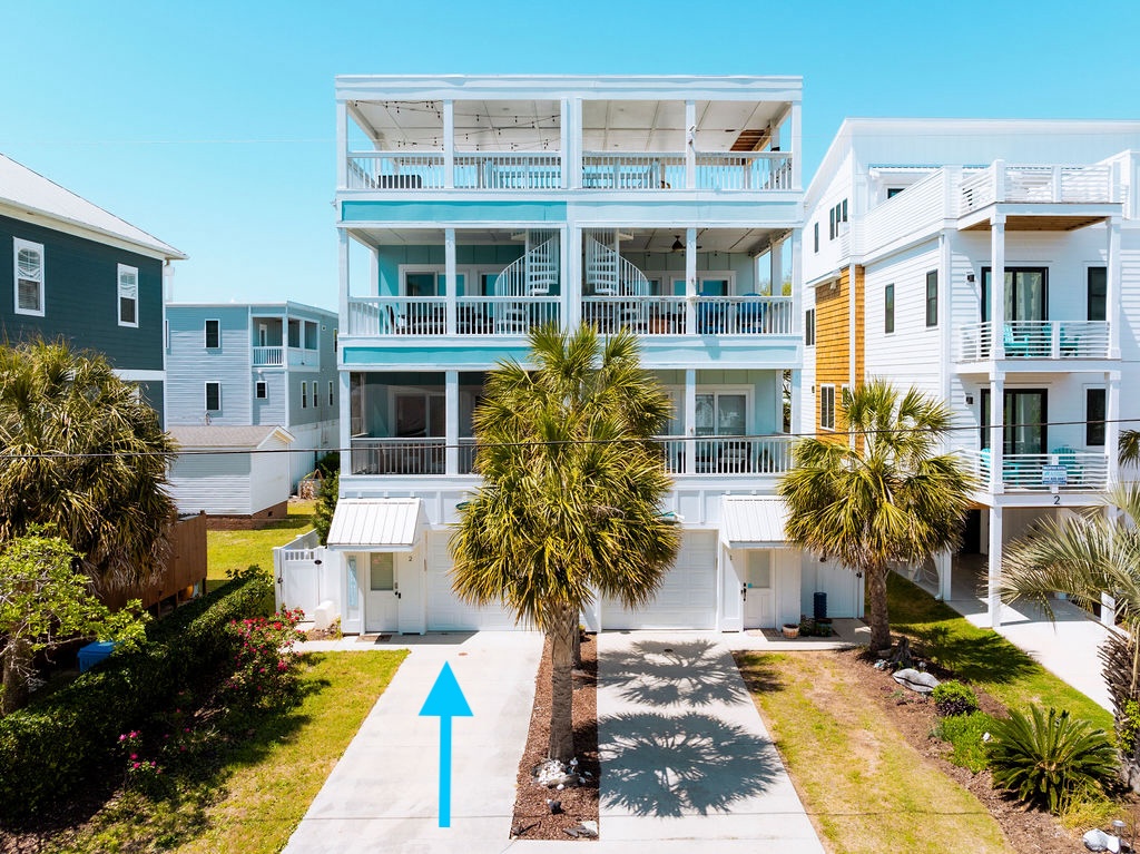 Beautiful coastal beach house with multiple levels and palm-tree landscaping in a charming neighborhood setting.