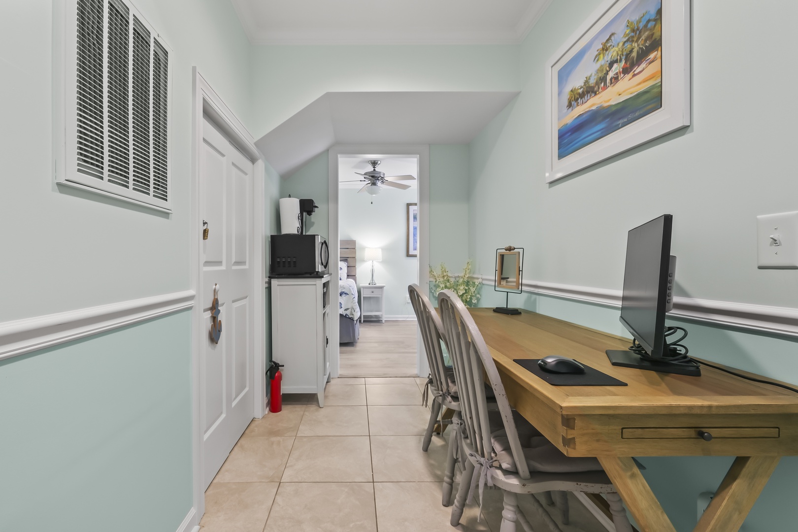 Your workspace awaits with coastal charm—settle in at this inviting desk, complete with modern tech, soft light, and beachy vibes just steps from your cozy retreat.