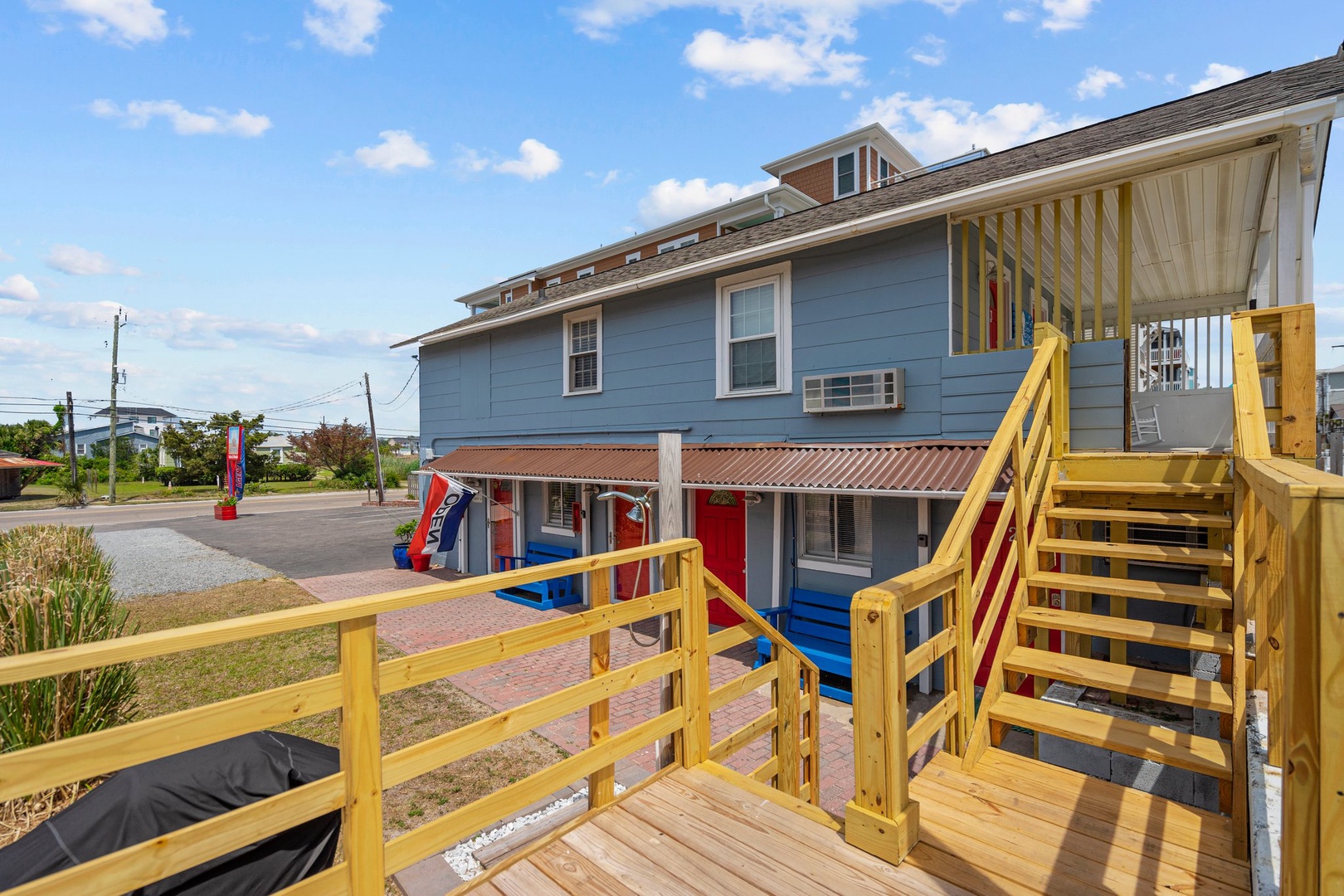 Coastal property featuring multi-level accommodations with colorful exterior details and convenient parking area.