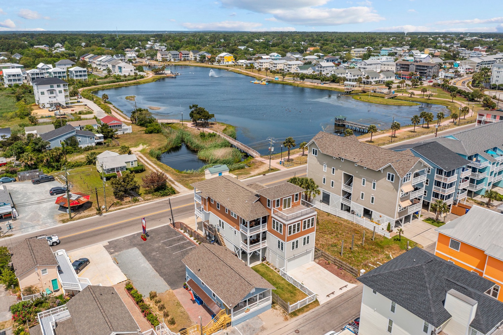 Aerial view of coastal community with waterfront homes surrounding a peaceful lagoon, showcasing the charming neighborhood setting.