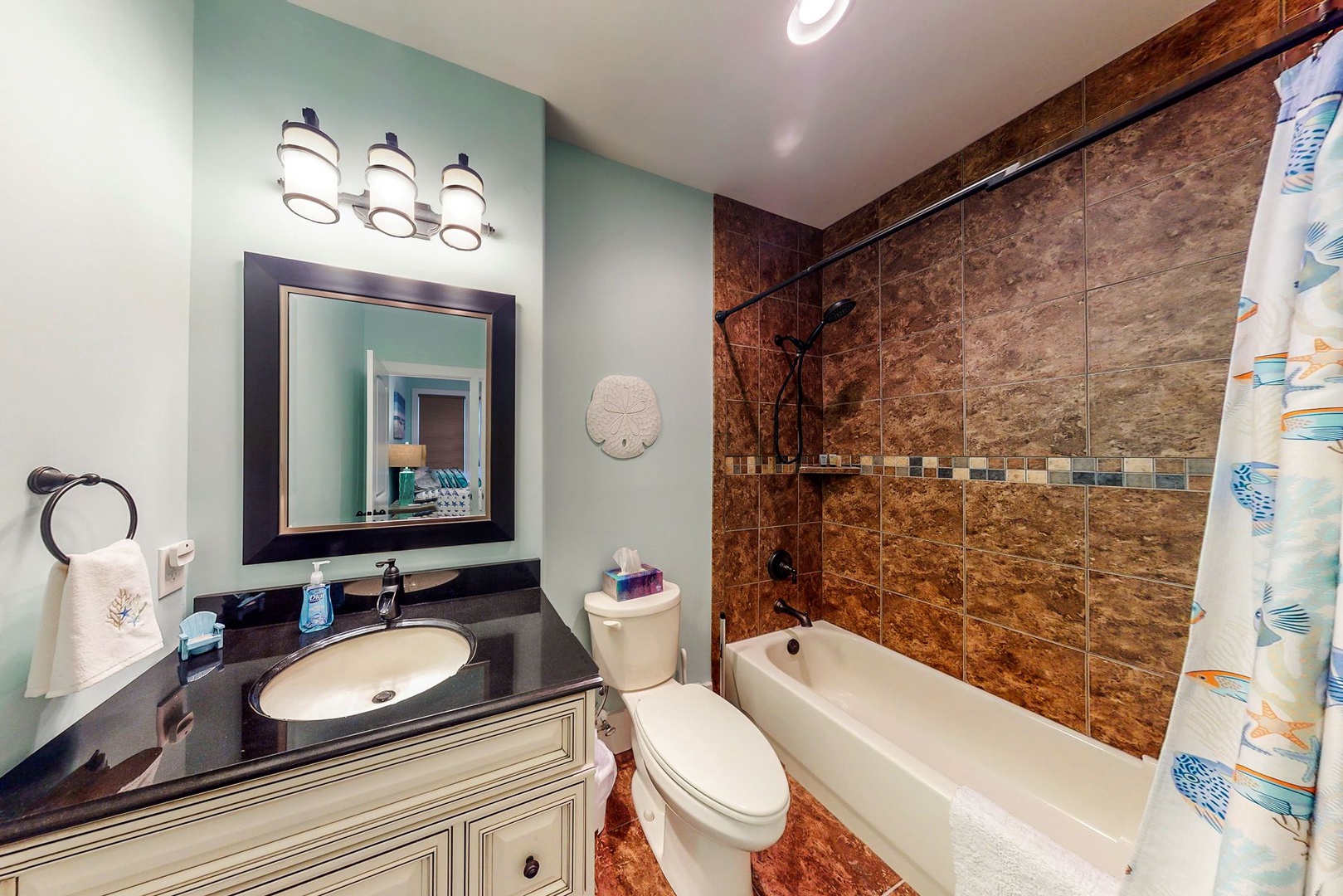 Unwind in your elegant bathroom featuring rich stone-tiled shower, modern lighting, and spa-like atmosphere for ultimate relaxation.