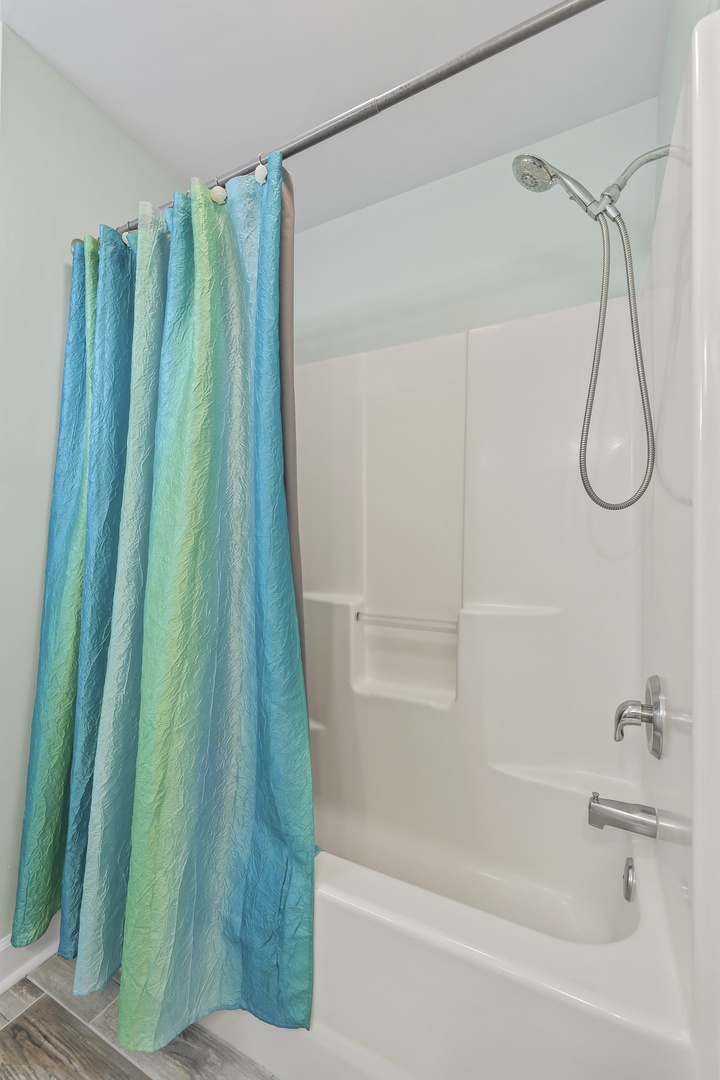 Your private bathroom features a clean tub-shower combo with modern fixtures and a handheld showerhead for comfort and convenience during your stay.