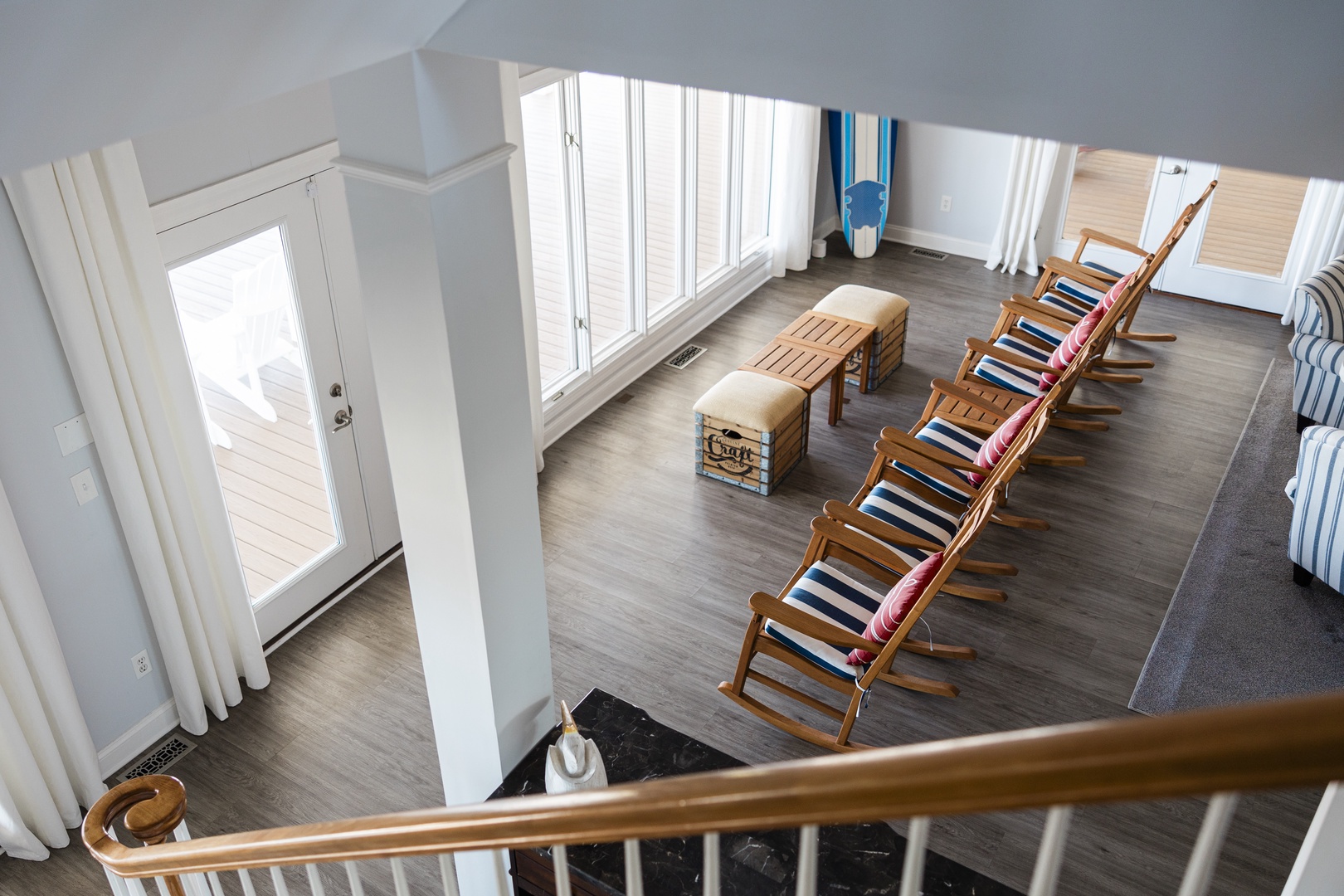 Your spacious living area flows beautifully with natural light, featuring comfortable striped lounge chairs perfect for afternoon reading and relaxation.
