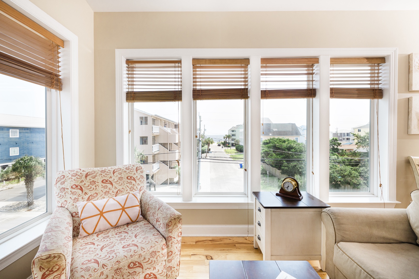 Relax in your bright living room while enjoying peaceful neighborhood views through large windows with stylish bamboo blinds.