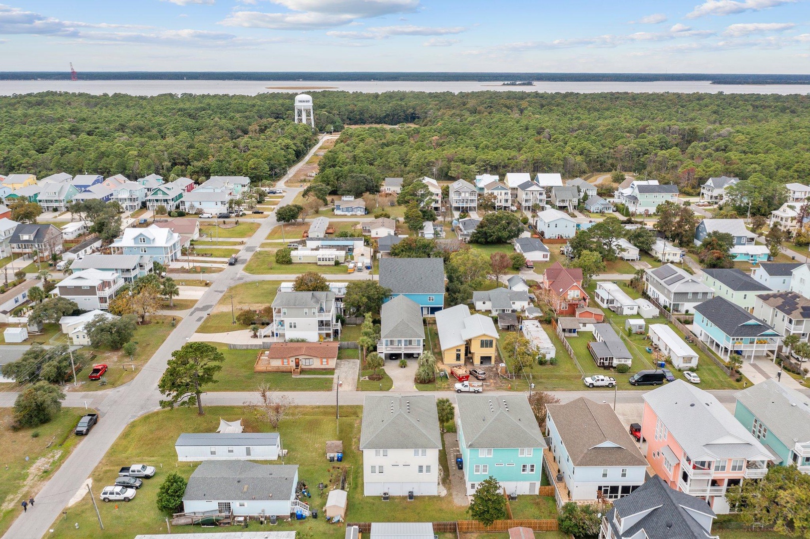 Charming coastal neighborhood with historic water tower backdrop near pristine waterfront.