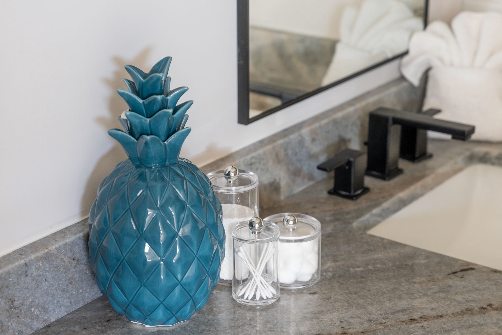 Your bathroom features thoughtful touches like a decorative pineapple accent and organized amenities to make your stay feel special.