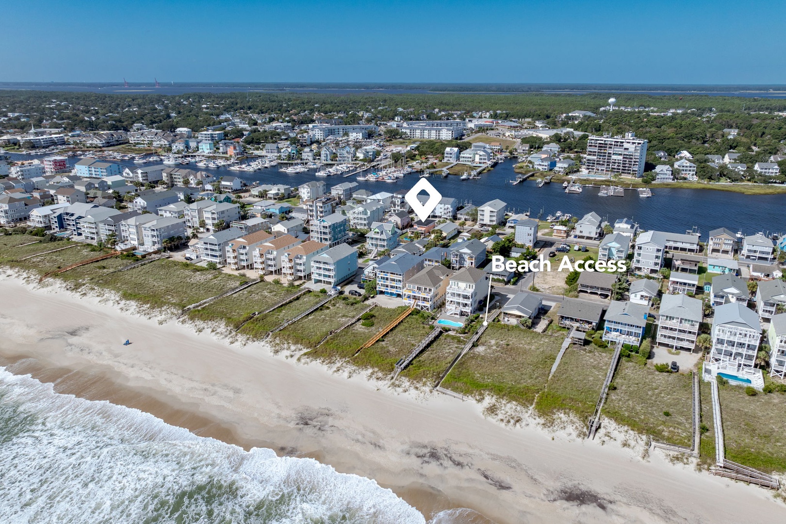Aerial view of beachfront community with direct beach access, waterways, and coastal residential properties.
