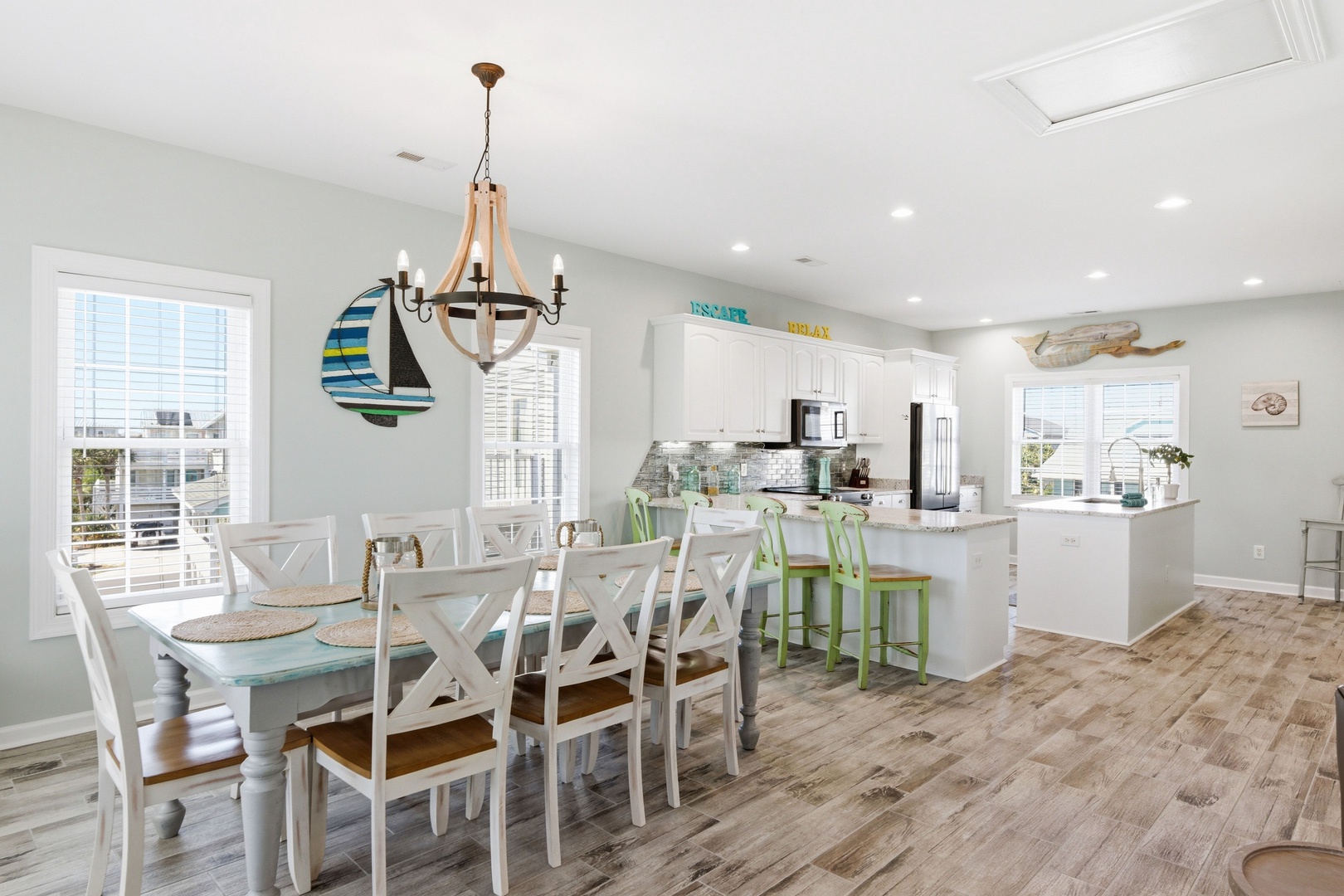Your bright, open-concept living space flows beautifully from dining to kitchen, with coastal charm and room for everyone to gather around the large table or breakfast bar.