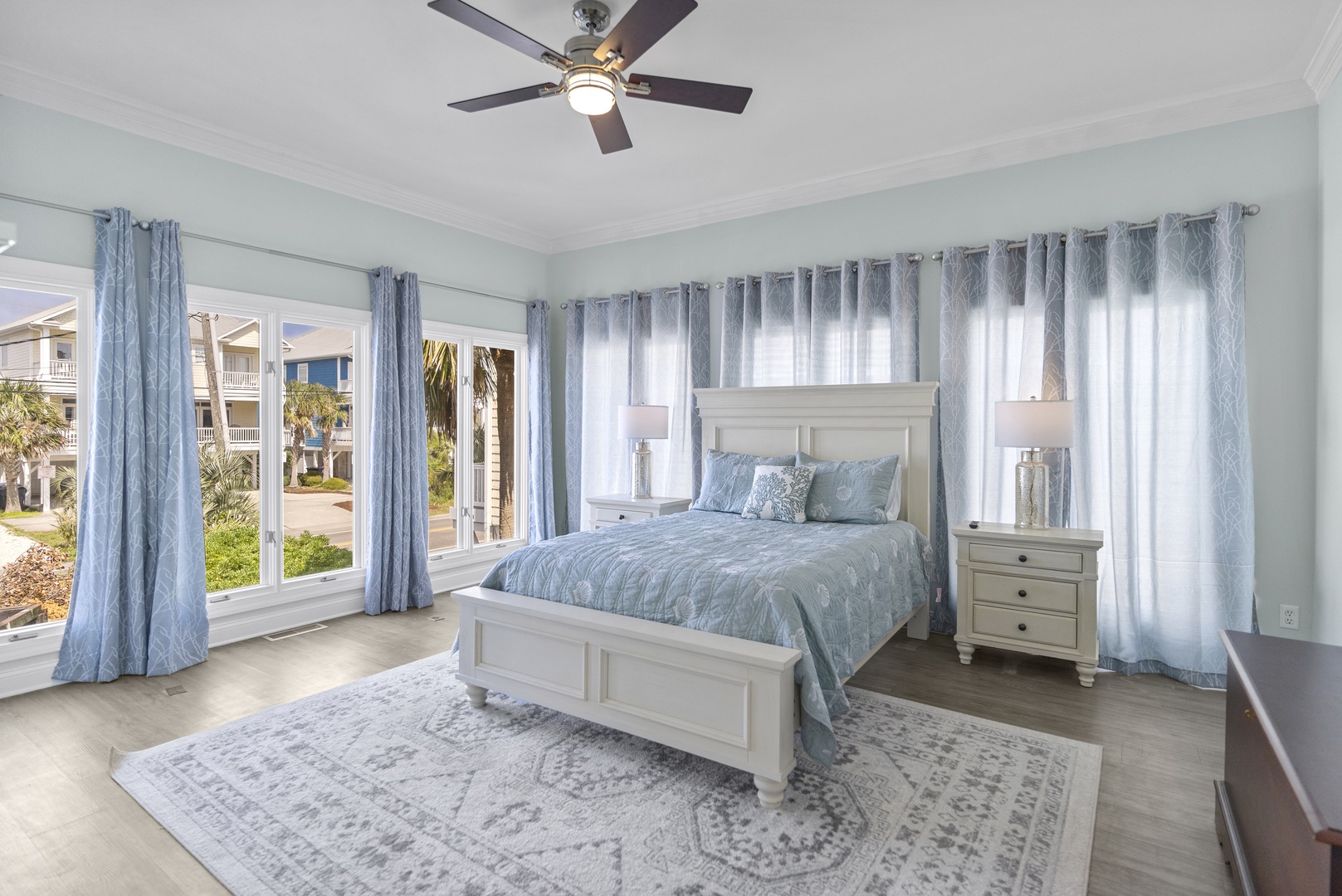 Drift off in this serene coastal bedroom with soft blue linens and peaceful views through your windows.