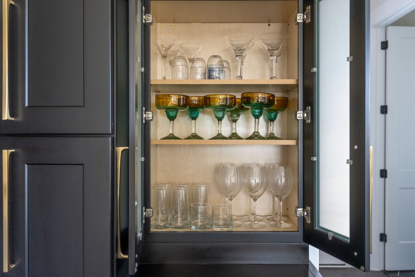 Your well-stocked glassware cabinet holds everything for memorable toasts and cozy evenings—from elegant wine glasses to colorful margarita stems.