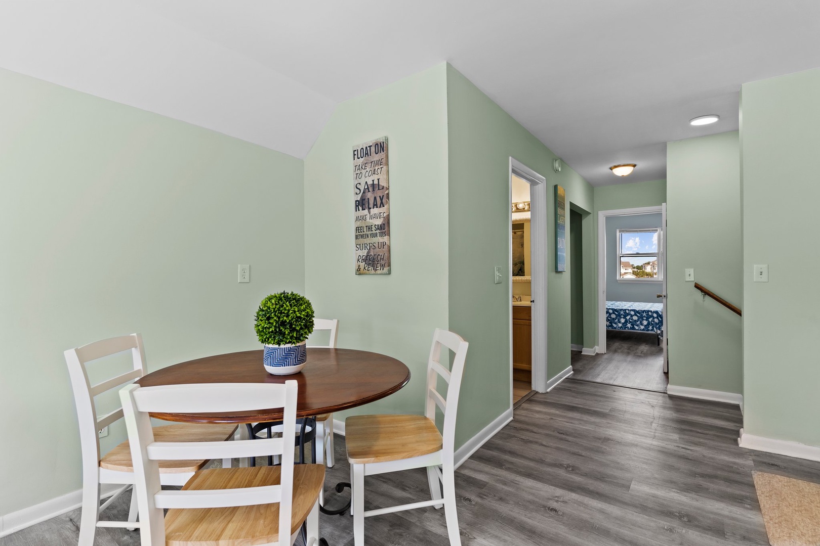 Your dining area features a cozy round table surrounded by charming white chairs, creating the perfect spot for intimate meals and morning coffee together.