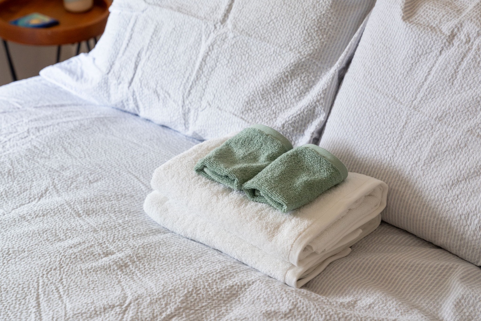Fresh towels await on your comfortable bed, thoughtfully arranged for your arrival and relaxation.