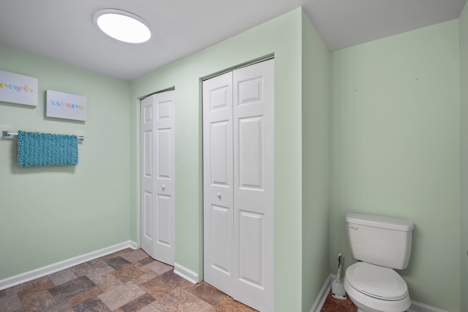 Spacious bathroom with soothing mint walls and ample wardrobe storage for all your belongings.