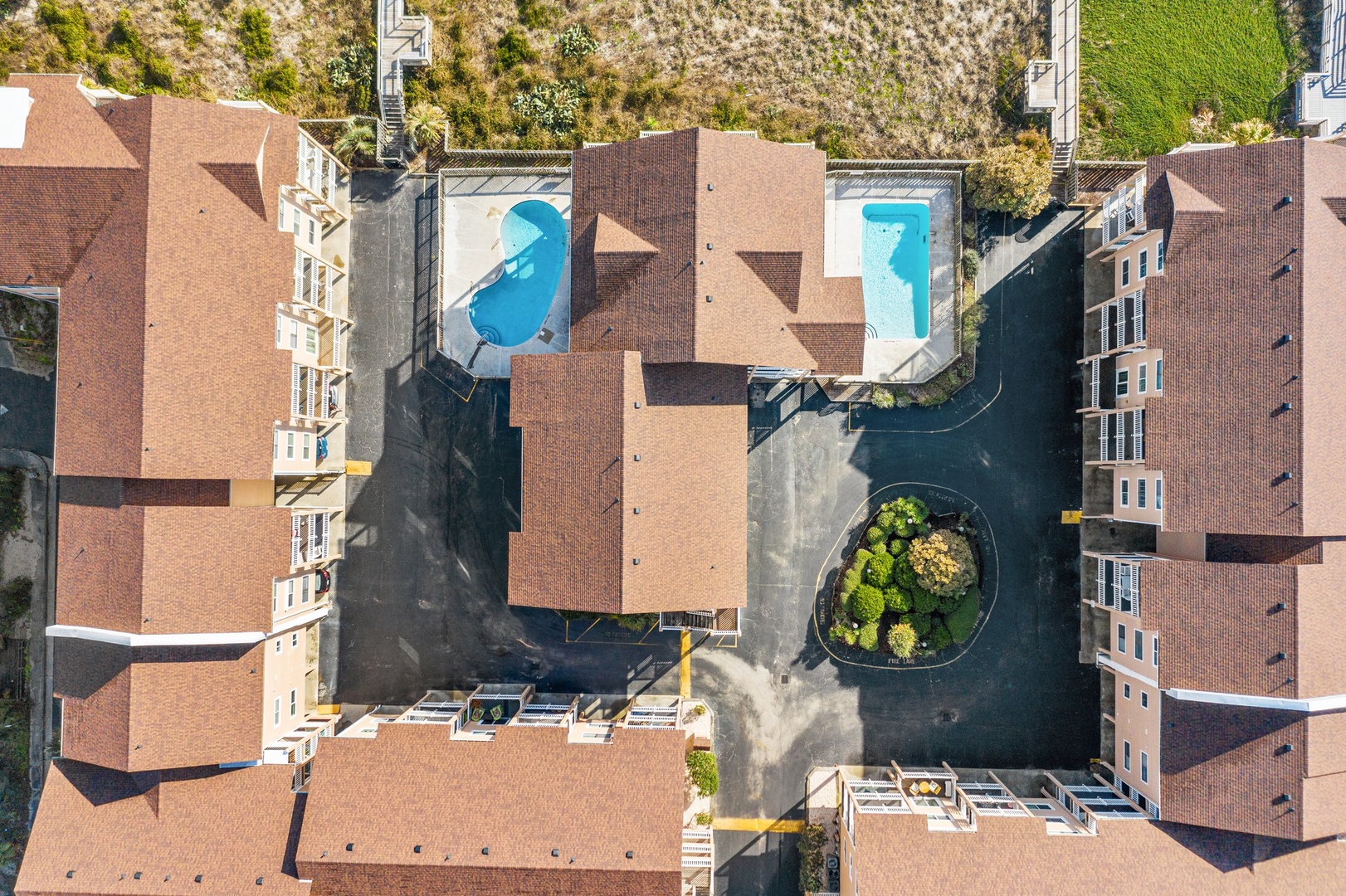 Aerial view of a well-appointed residential complex featuring multiple swimming pools and landscaped courtyards surrounded by multi-story buildings.
