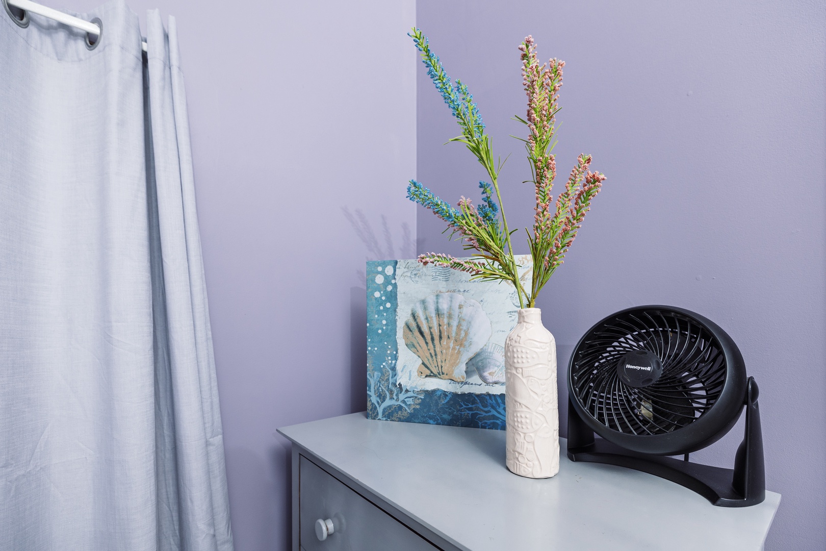Your dresser holds fresh wildflowers and thoughtful details, while a quiet fan ensures your comfort throughout your stay.