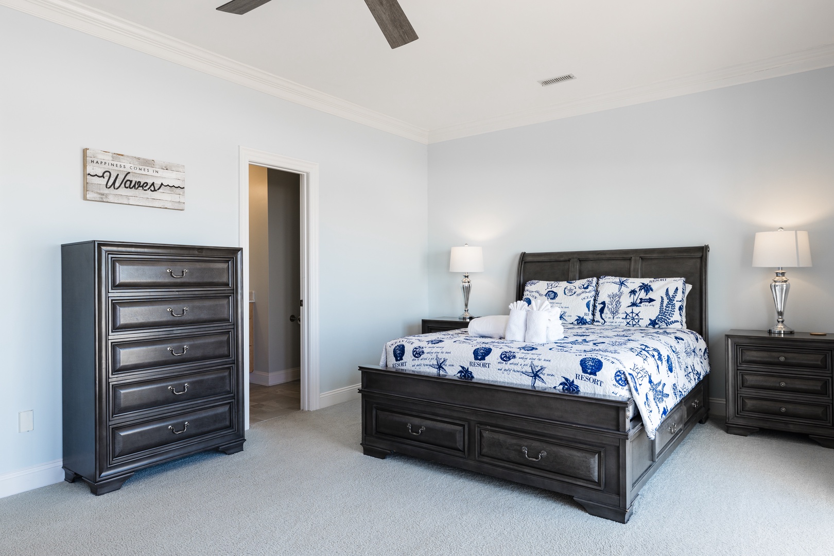 Drift off to sleep in your coastal-themed bedroom, where nautical blue linens and rich dark wood furniture create the perfect seaside retreat.