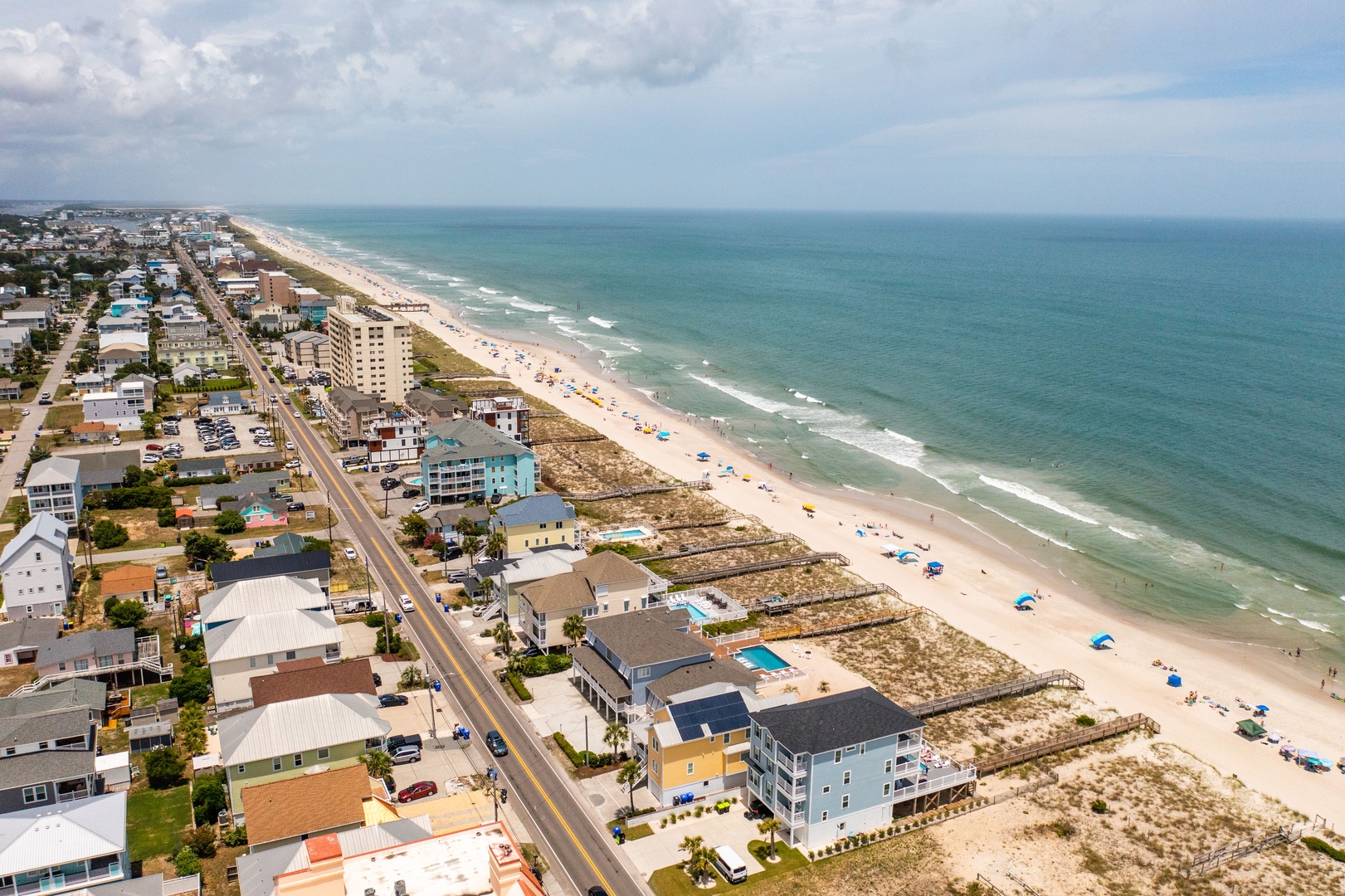 Stunning beachfront community with miles of pristine coastline and colorful beach umbrellas dotting the sandy shores.