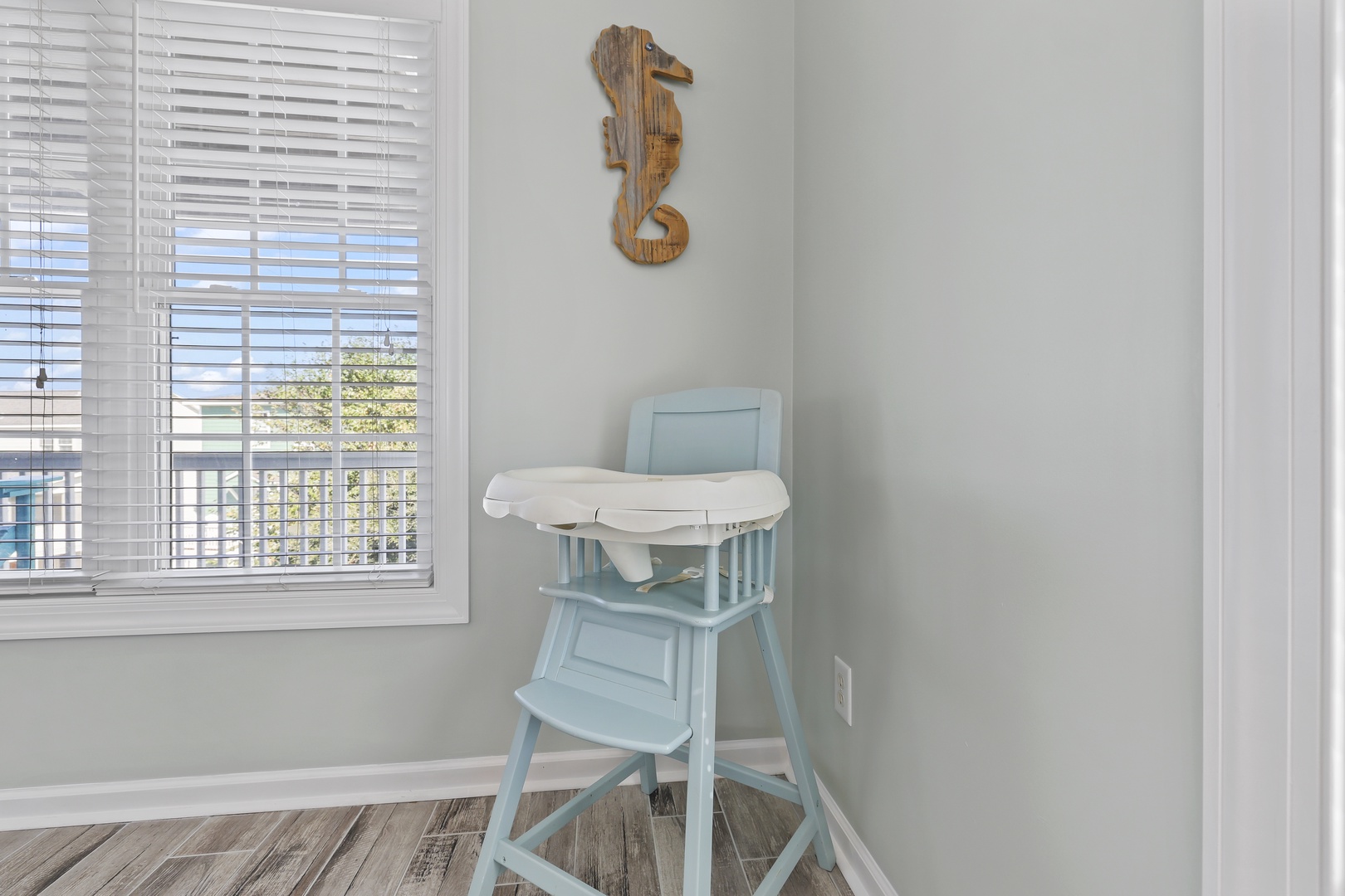 Coastal charm meets convenience with this vintage high chair, perfectly placed by natural light and adorned with beachy décor for your little one's mealtimes.