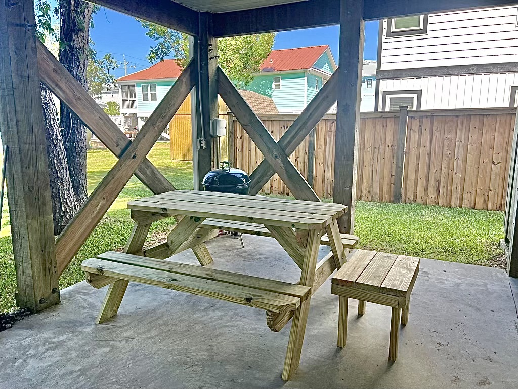 Your private covered patio offers the perfect spot for outdoor dining with a picnic table, BBQ grill, and peaceful yard views.