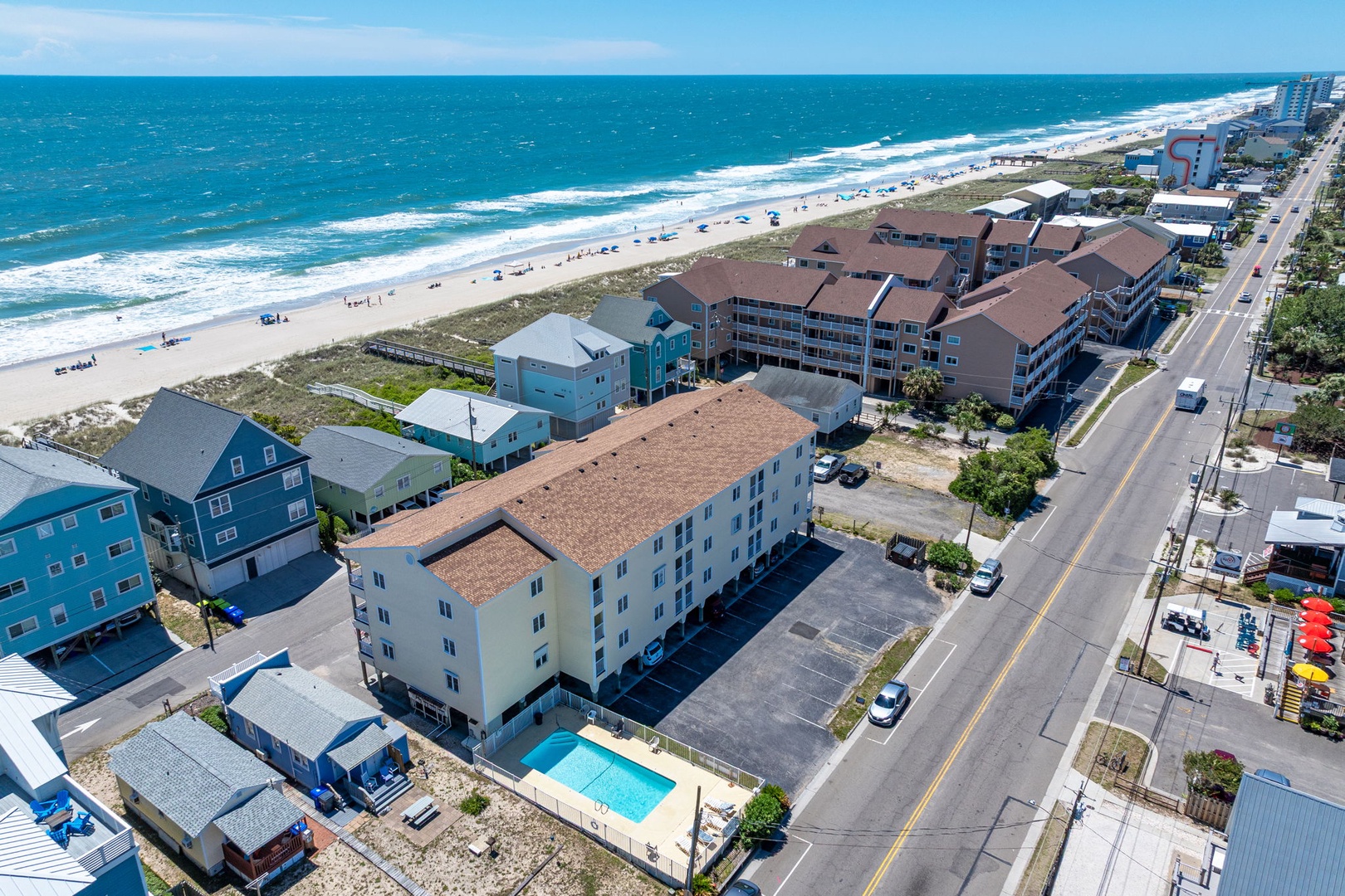Beachfront property featuring direct access to sandy shores and turquoise waters. The location offers a classic coastal setting with ocean views and convenient parking.