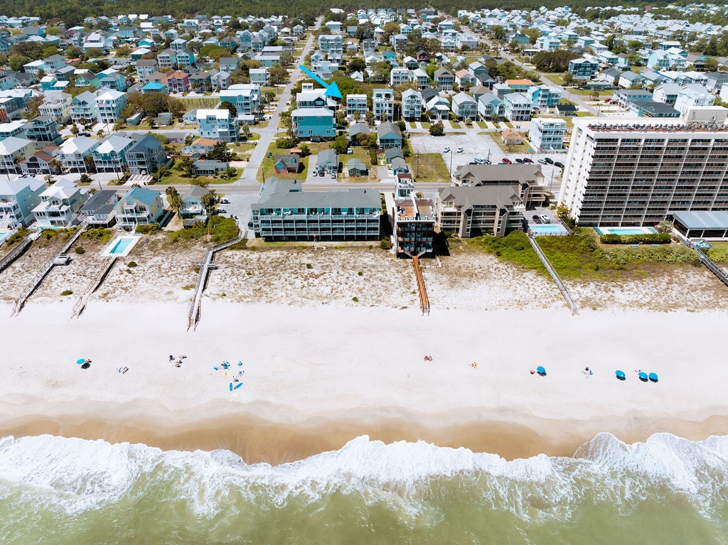 Aerial view of beachfront vacation rental community with direct beach access and pristine sandy shoreline perfect for coastal getaways.
