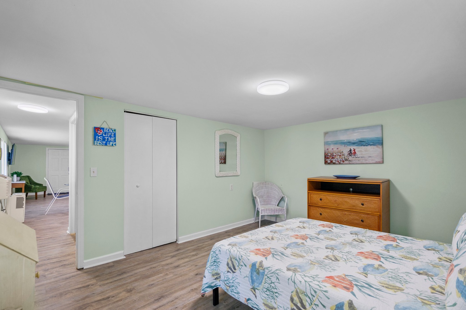 Relax in your peaceful bedroom with cheerful coastal decor, soft green walls, and convenient storage to make you feel at home.