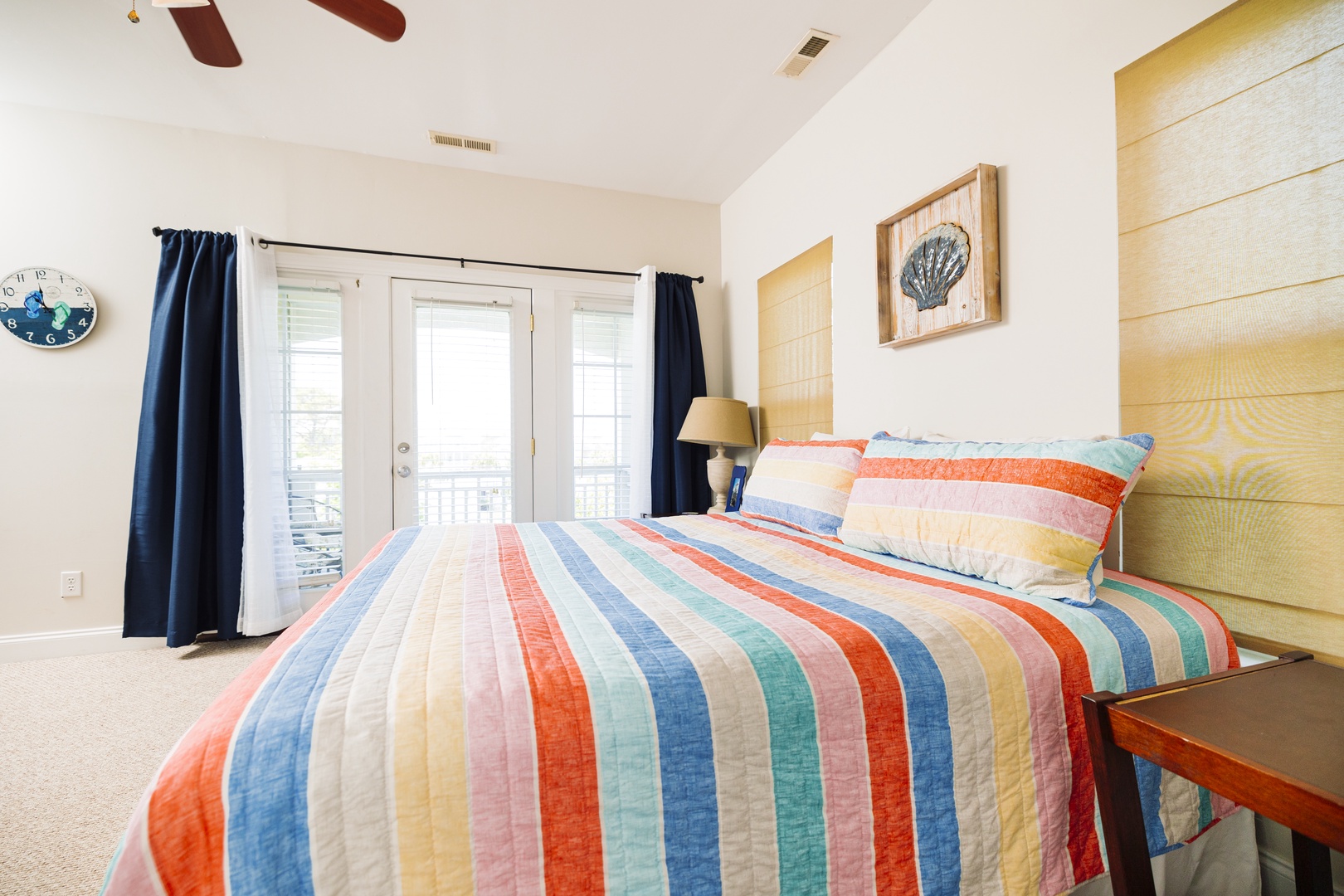 Wake up in your cheerful coastal bedroom where colorful striped linens and natural wood create a perfect beachside retreat for restful nights.