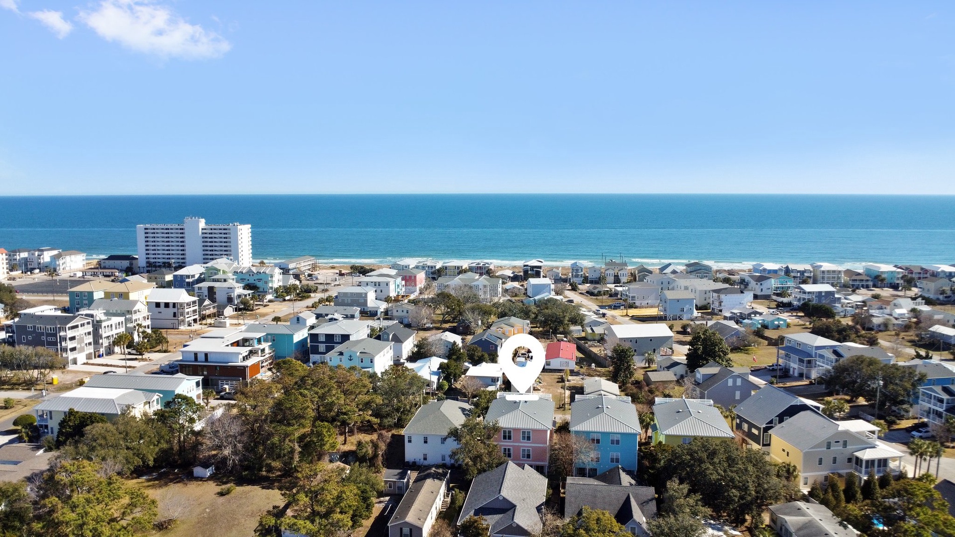 Aerial view of coastal town with beachfront location and nearby amenities in a charming residential neighborhood.