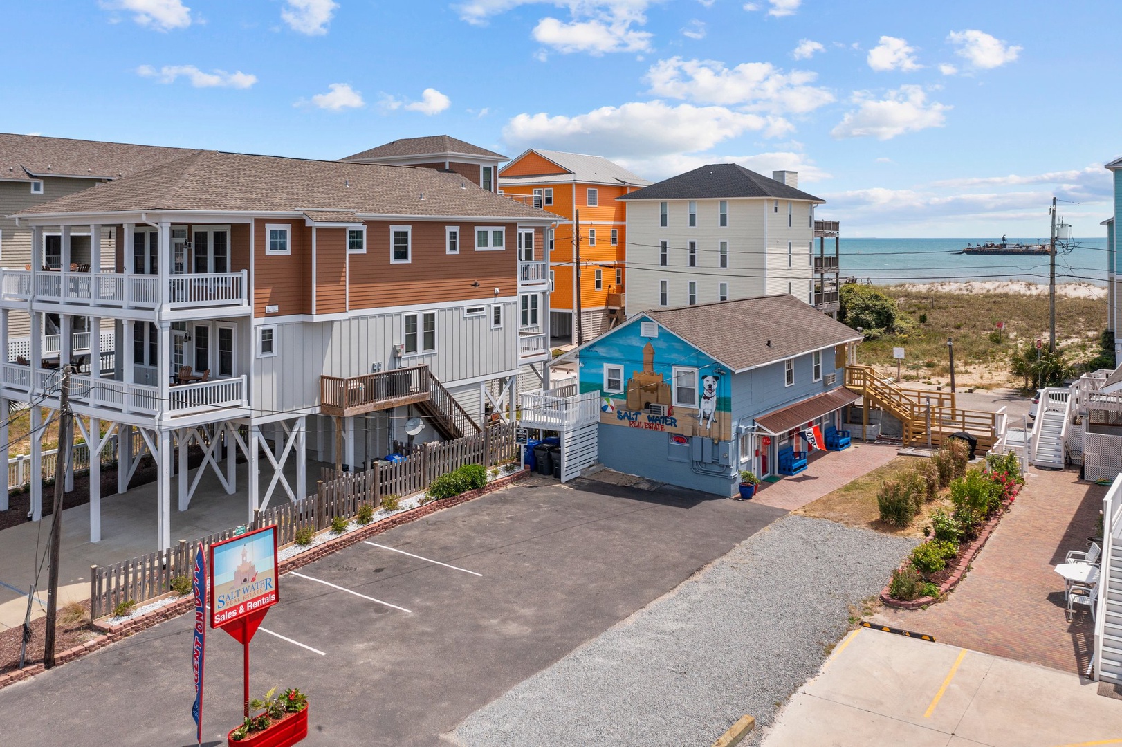 Colorful beachfront properties with elevated structures and convenient parking just steps from the ocean.