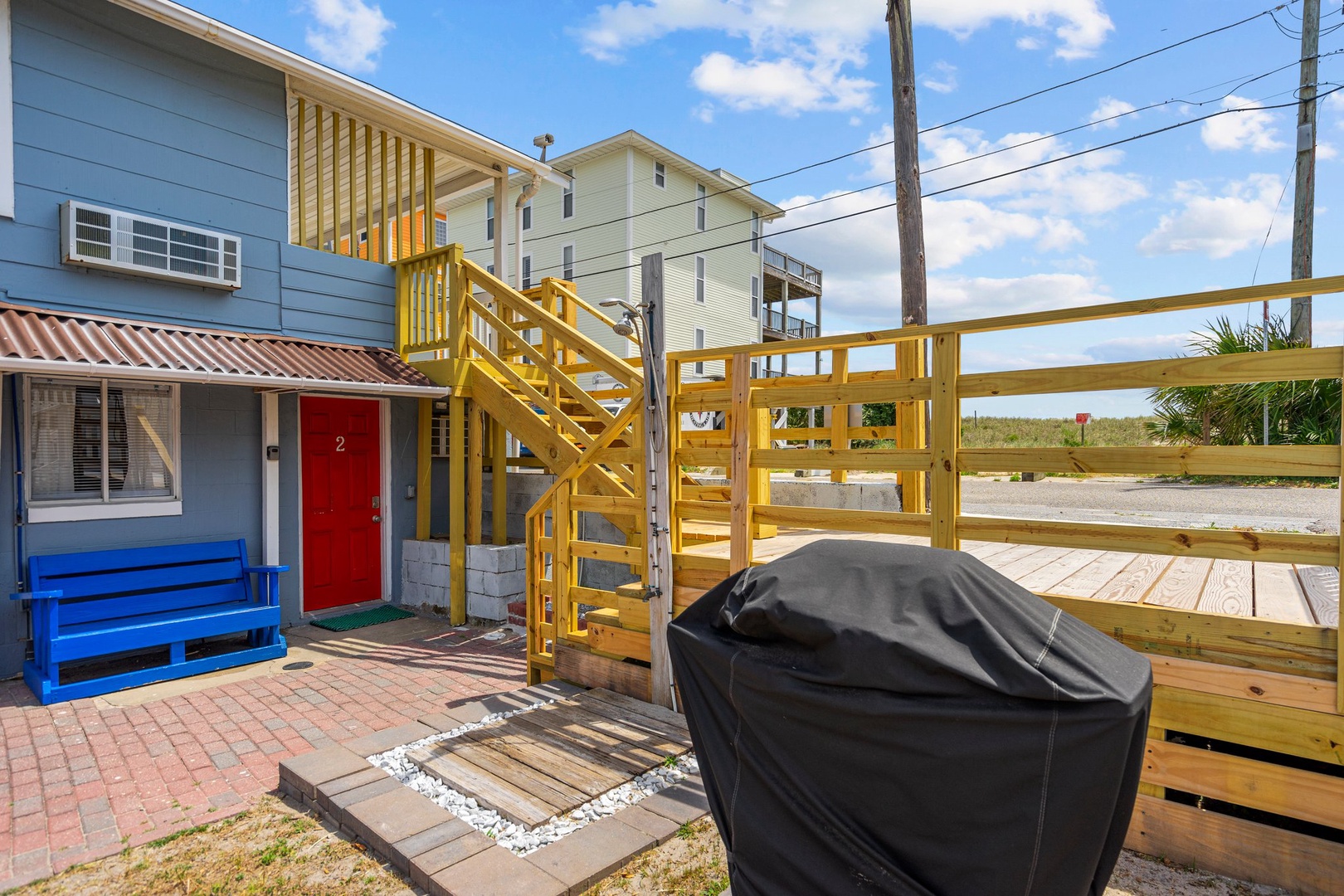 Your private deck features a covered grill for beachside BBQs, with colorful coastal charm steps away from sandy shores.