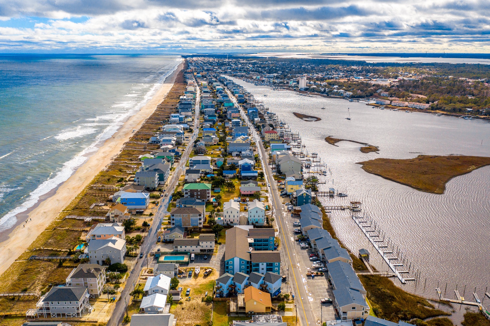 Aerial view of a coastal community with beach access and waterfront marina facilities.