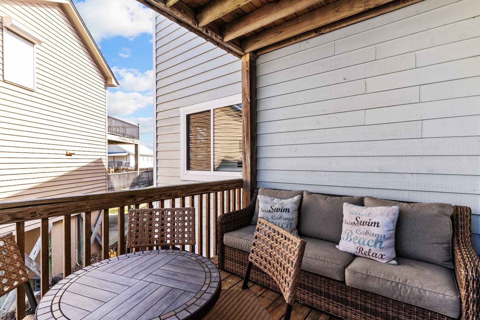 Relax on your private balcony with comfortable wicker seating and coastal-themed pillows—perfect for morning coffee or evening wind-downs.
