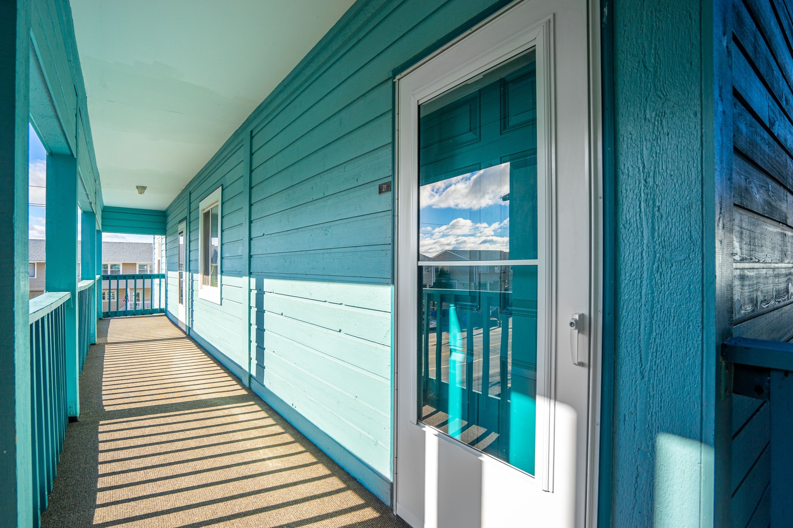 Your private covered balcony offers a peaceful retreat with charming turquoise railings and natural light streaming through.