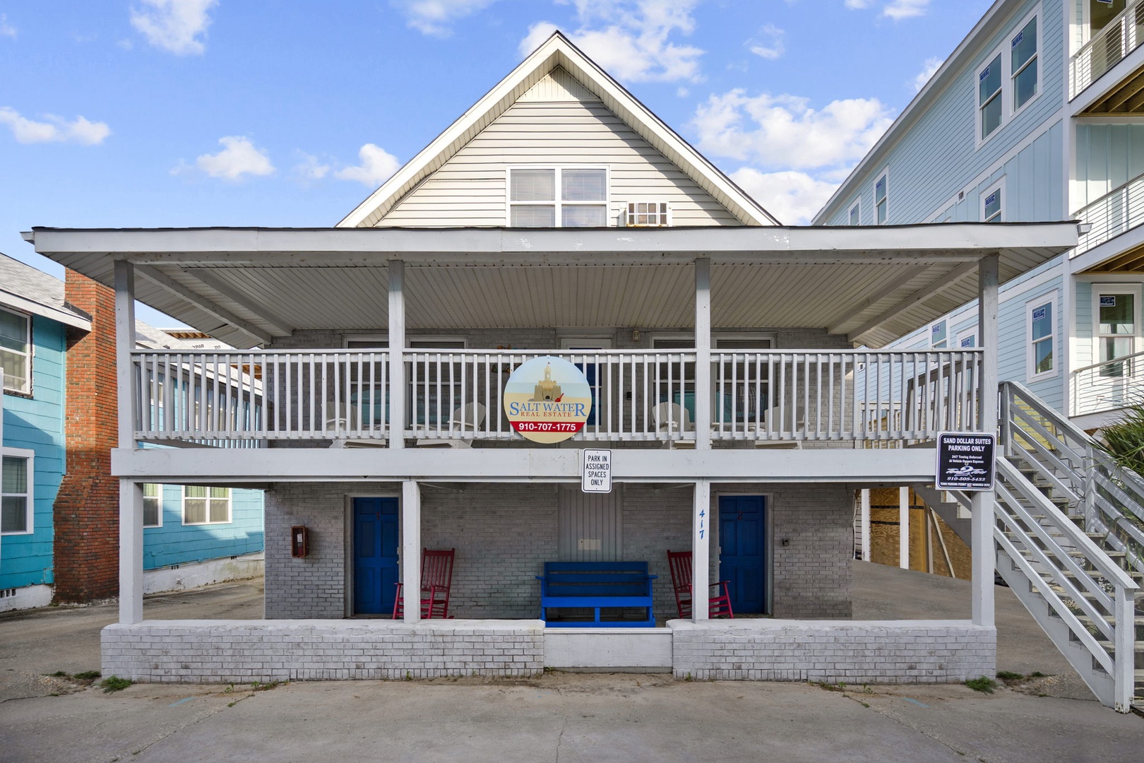 Classic beach property exterior featuring two levels with covered porch seating and coastal neighborhood charm.