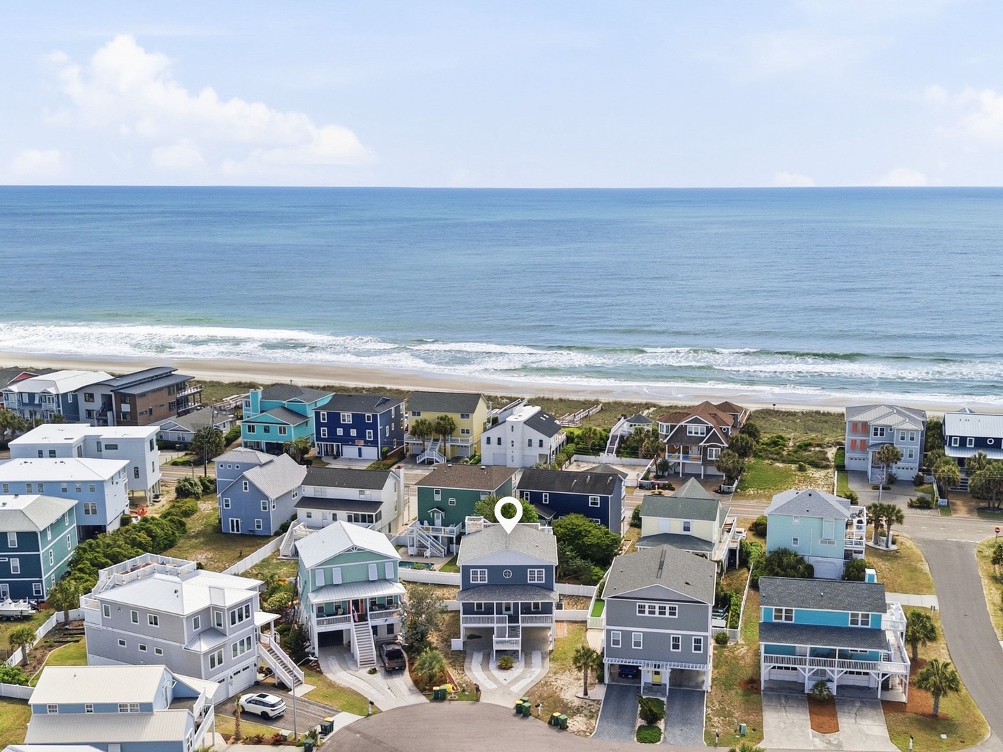 Coastal neighborhood with beach homes nestled between ocean and quiet streets, moments from sandy shores and rolling waves.