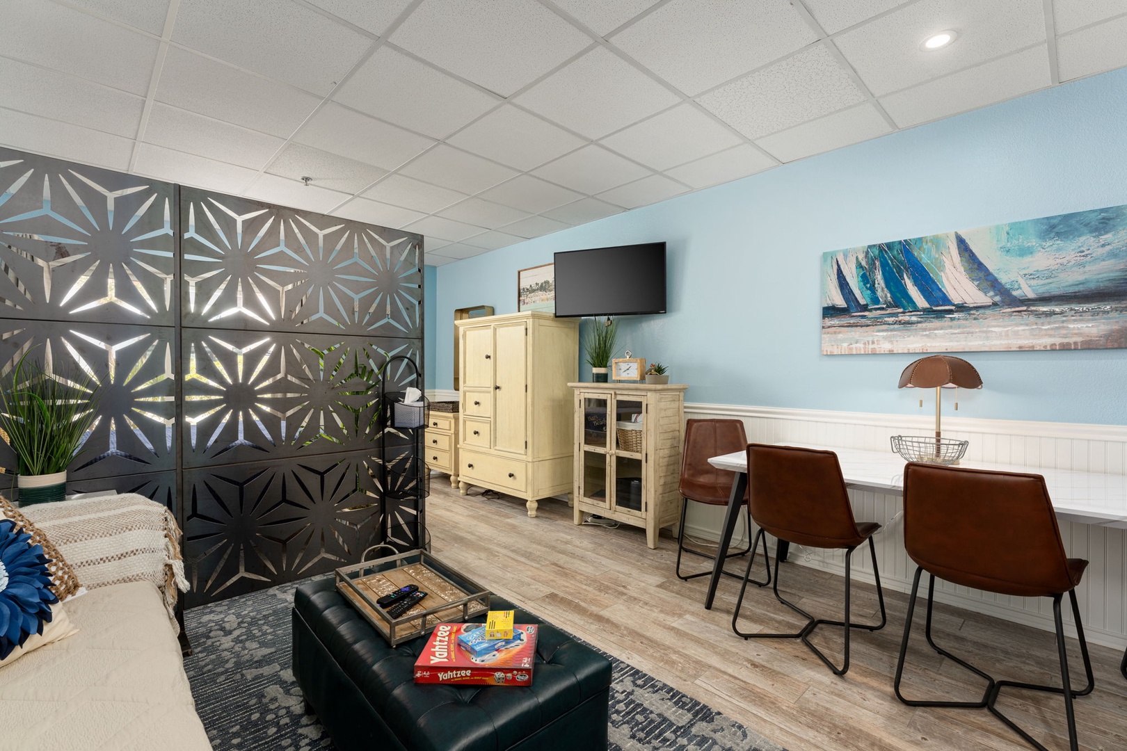 Unwind in this stylish lounge with coastal artwork, comfy seating, and entertainment—perfect for relaxing after your adventures.