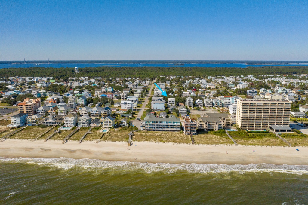 Aerial view showcasing the beachfront property location along pristine coastline with ocean access and nearby residential community.