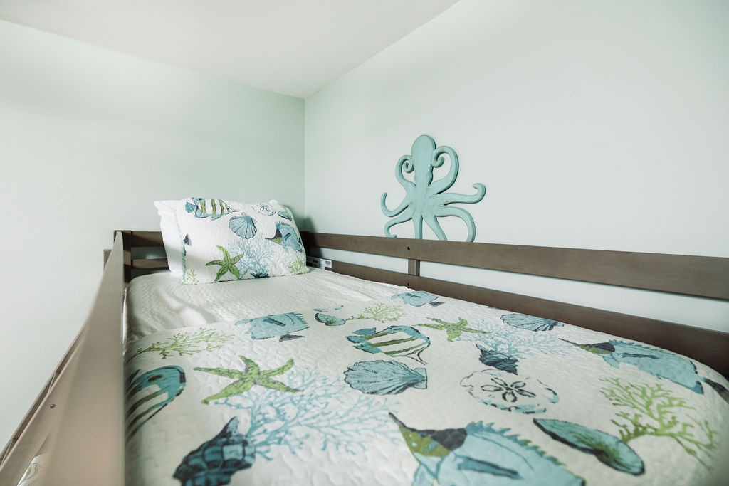 Drift off in this ocean-themed bedroom where sea-life bedding and playful octopus art create your perfect coastal retreat.