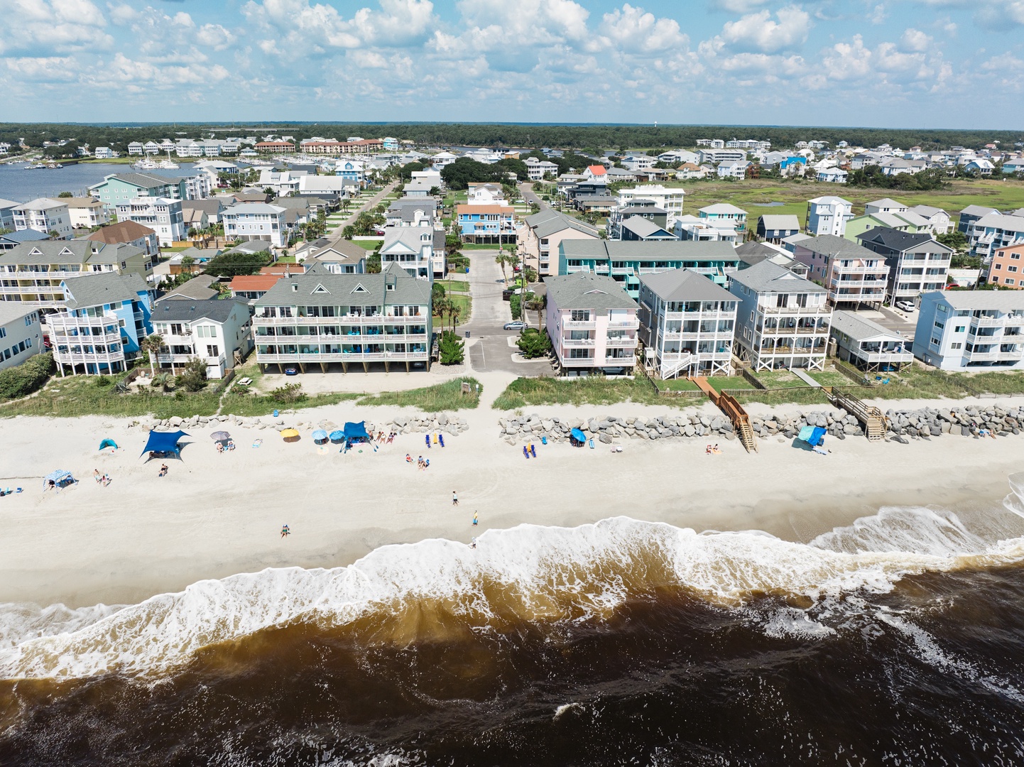 Aerial view of beachfront vacation rental properties with direct beach access and coastal neighborhood surroundings.