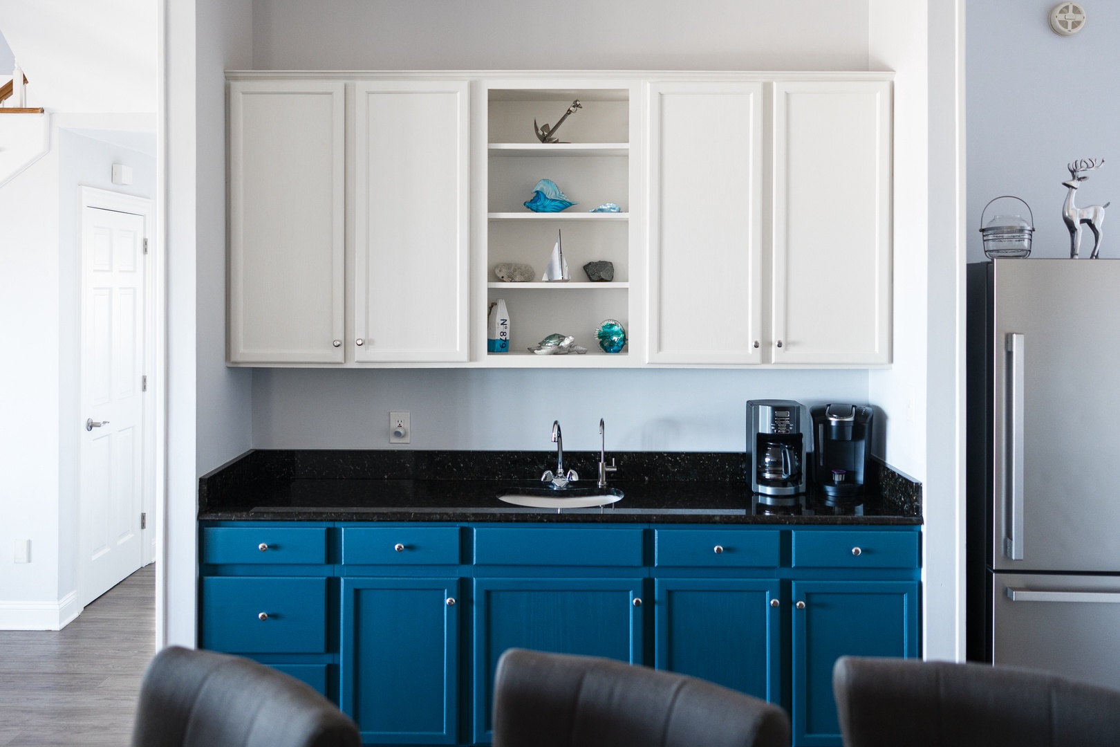 Your bright kitchen features striking blue cabinets and modern appliances, perfect for preparing morning coffee or evening snacks.