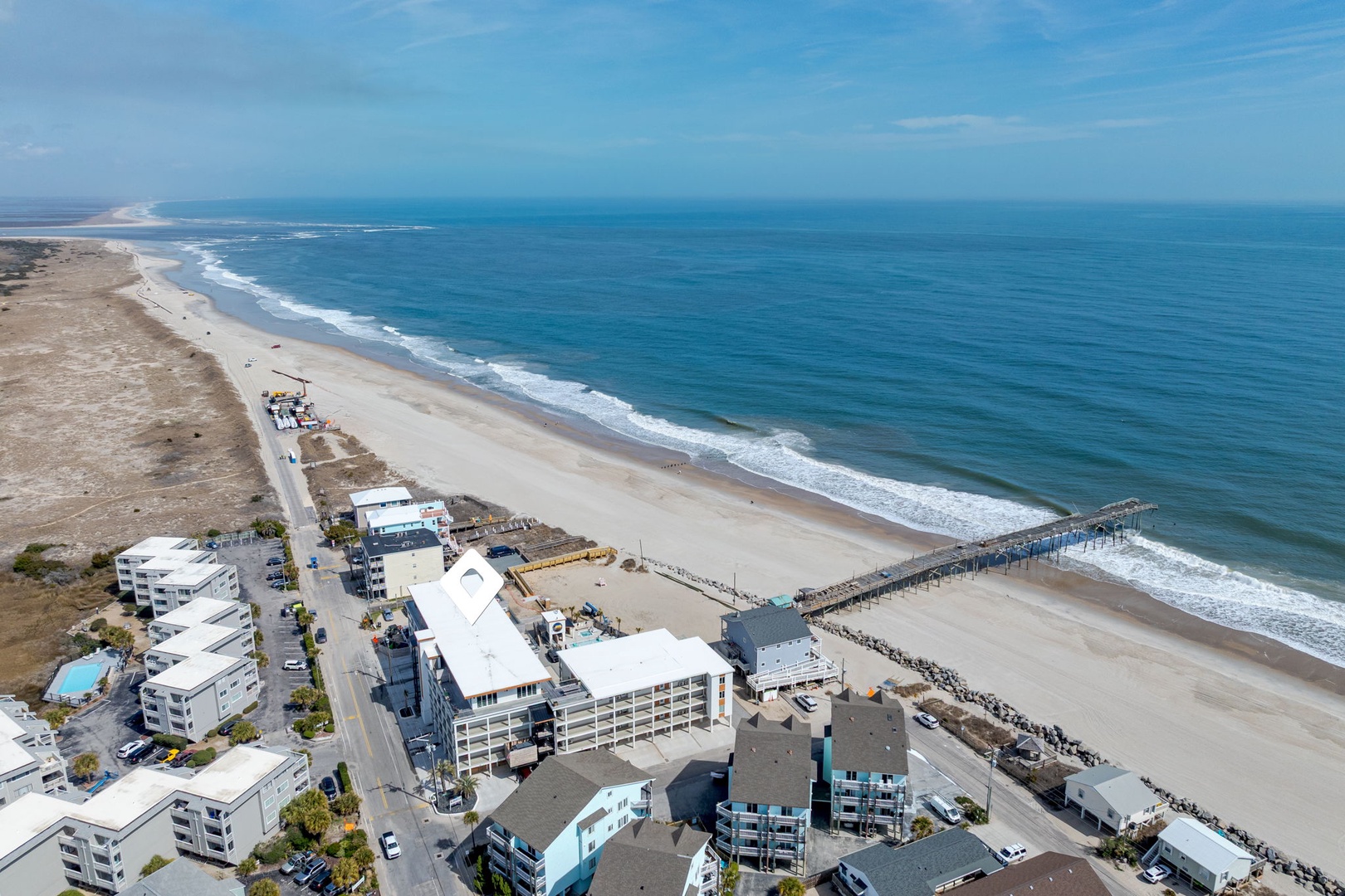 Stunning aerial view of pristine beachfront with expansive sandy shores and crystal-clear waters stretching to the horizon.
