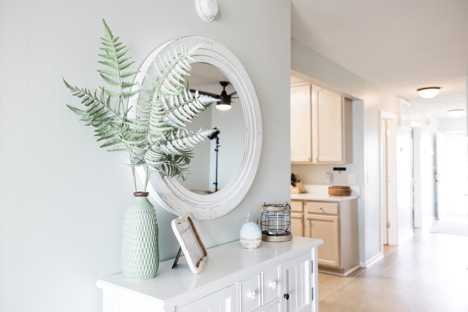 Discover your stylish entryway featuring elegant decor and fresh greenery, with your fully-equipped kitchen just steps away.