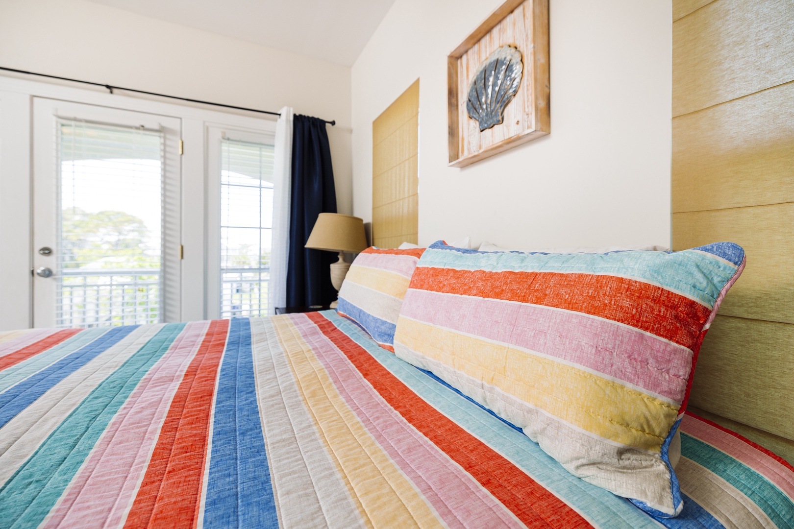 Drift off to sleep wrapped in cheerful rainbow stripes, while gentle ocean breezes flow through your private balcony doors.