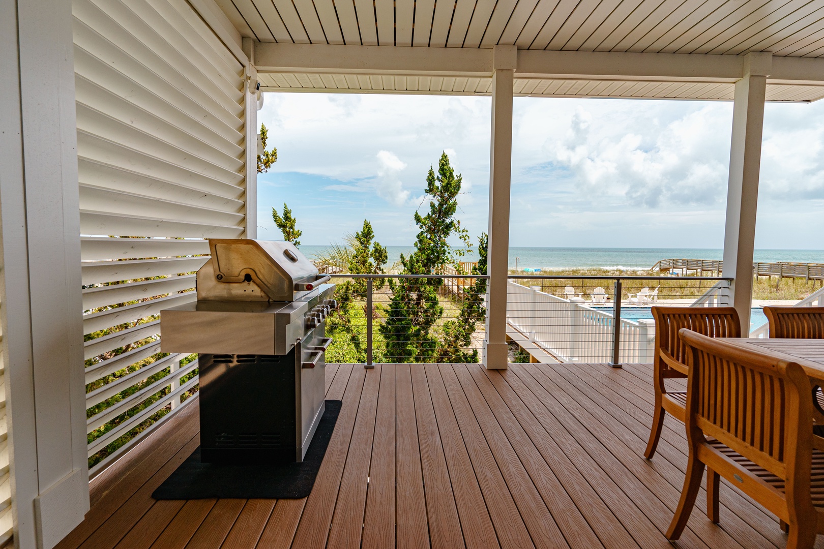 Your private balcony features a built-in BBQ grill and dining space with stunning ocean views—perfect for seaside grilling.