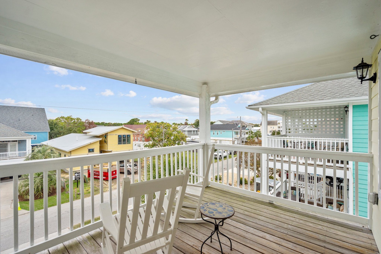 Your private covered balcony offers peaceful neighborhood views with comfortable seating perfect for morning coffee or evening relaxation.