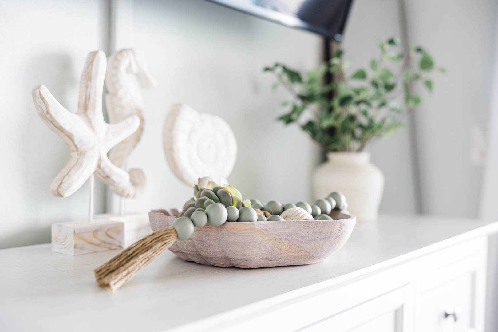 Your coastal-inspired kitchen features thoughtful decor with natural textures and greenery, creating a serene cooking space.