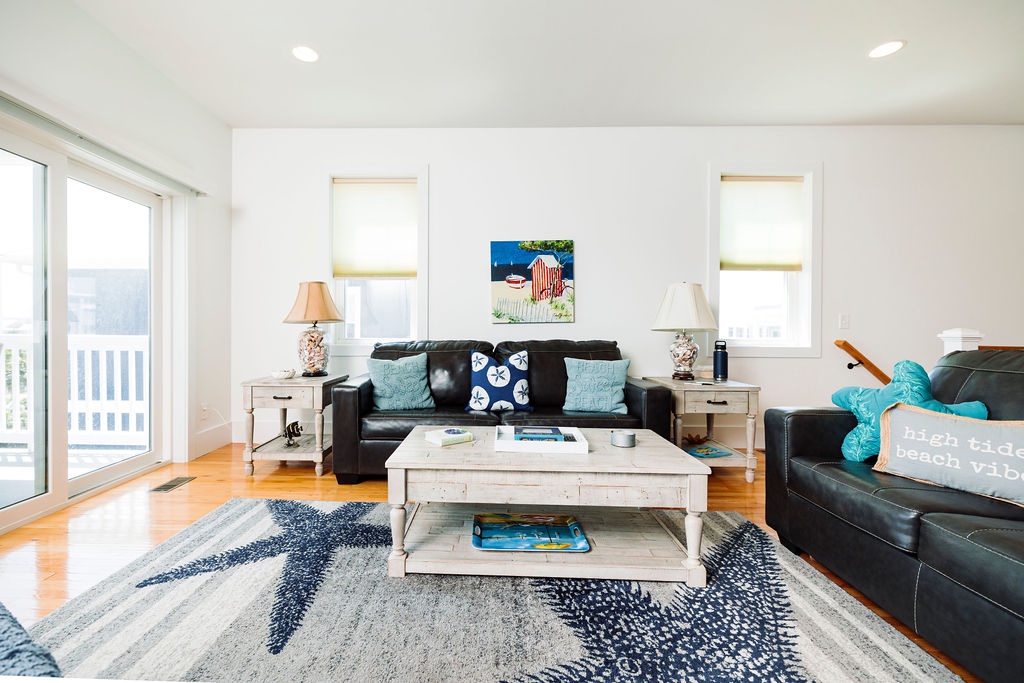 Sink into plush leather sofas with coastal charm surrounding you in this bright living space, perfect for relaxing after beach adventures.