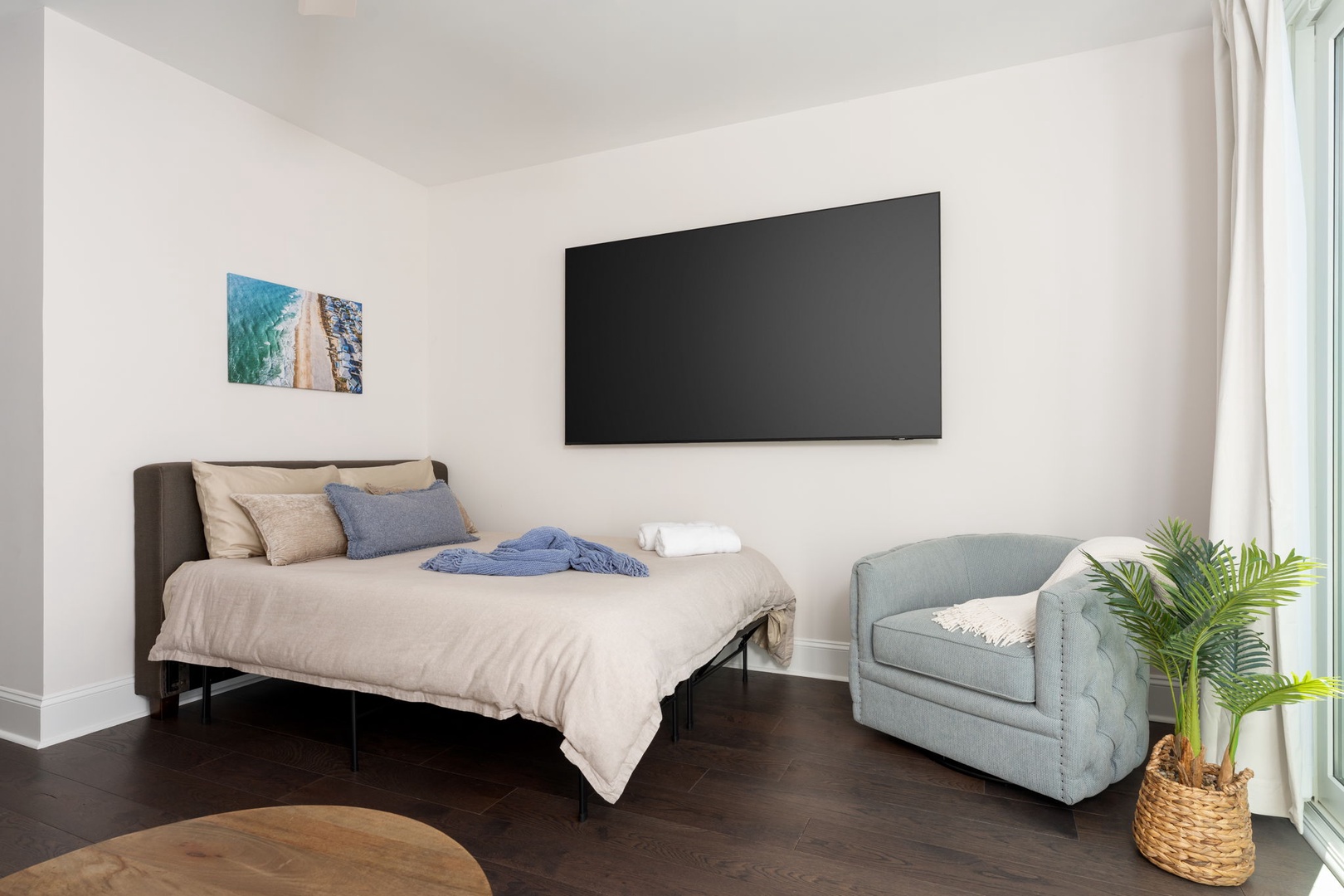 Your comfortable bedroom features a cozy reading chair and large TV for relaxing evenings after exploring the area.