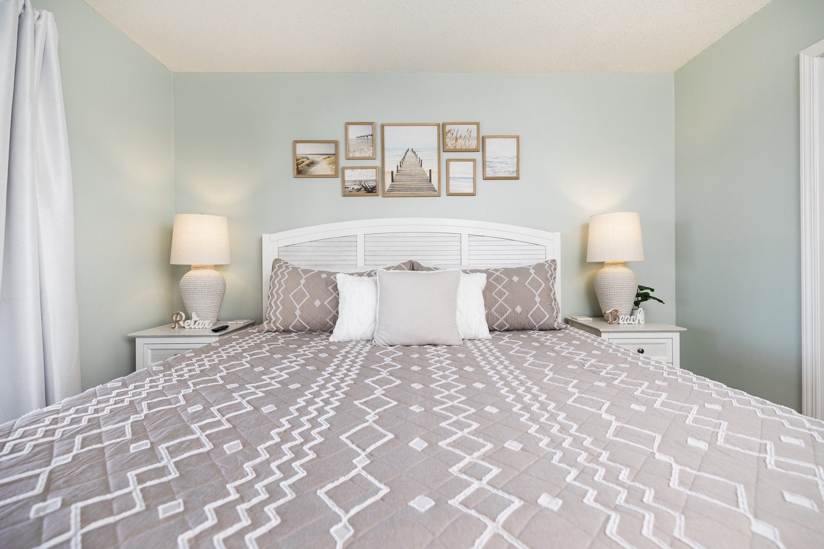 Drift into peaceful sleep in this serene bedroom with coastal decor, soft lighting, and luxurious linens.